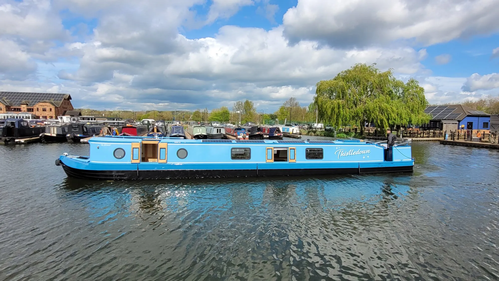 Narrowboat Thistledown, painted light blue, moored at the marina