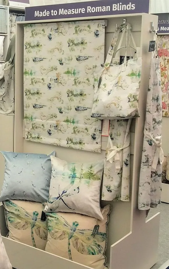 Aqua Furnishings display of made to measure Roman blinds, cushions and bags in a dragonfly print